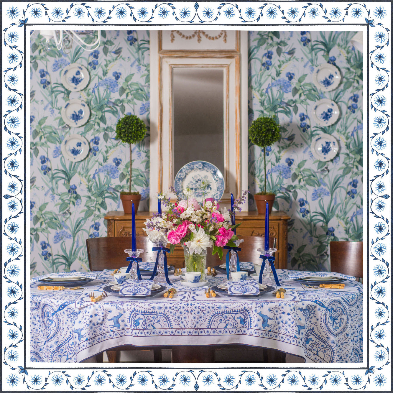 Dining room with floral wallpaper, table set with blue and white decor, and floral centerpieces.